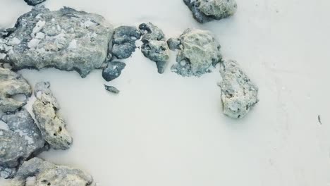 drone-flight-over-white-beach-and-stones