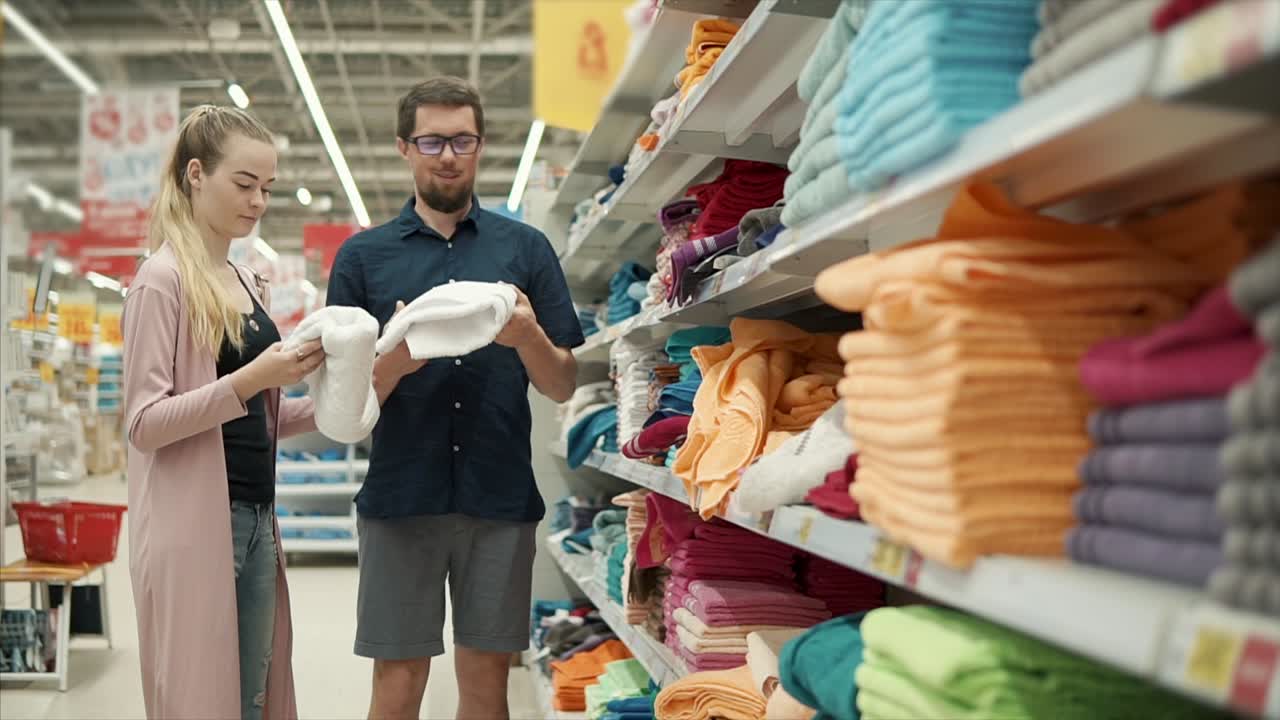 una pareja comprando toallas en un supermercado.