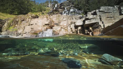 un video relajante presenta las maravillas naturales de un río, con agua clara y una cascada en inusuales acantilados cuadrados