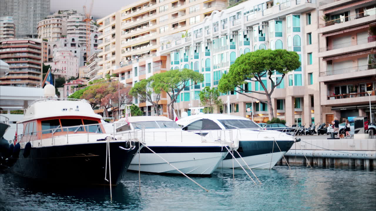 View of boats docked in the Monaco Marina with the skyline of the city on the background