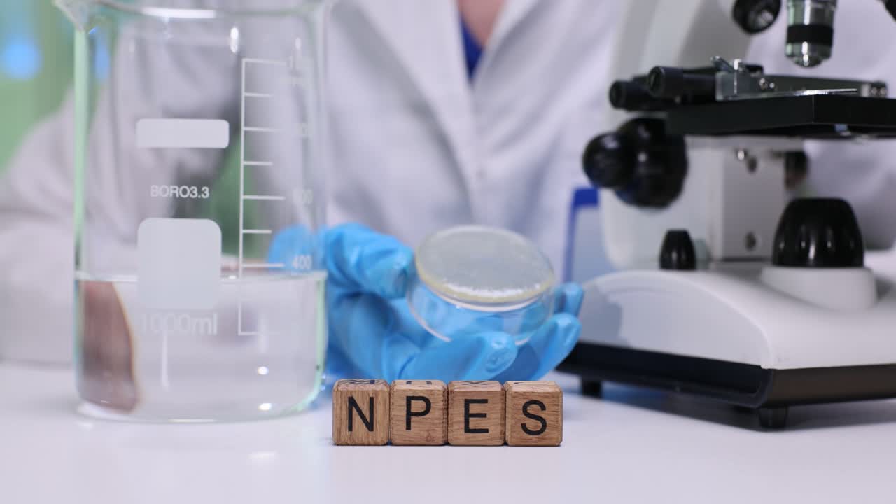 Scienziato che tiene una capsula di Petri in laboratorio con blocchi NPES