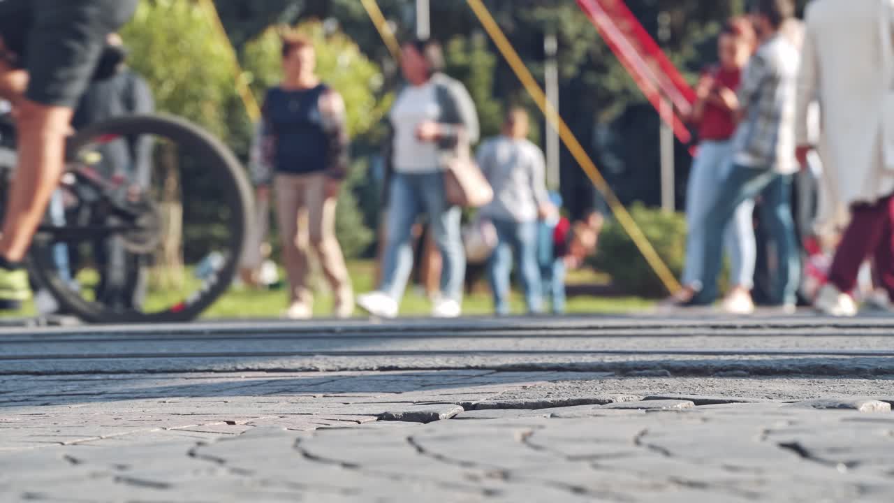 Crowd walking on sidewalk. Legs and feet of group of people walking on city square