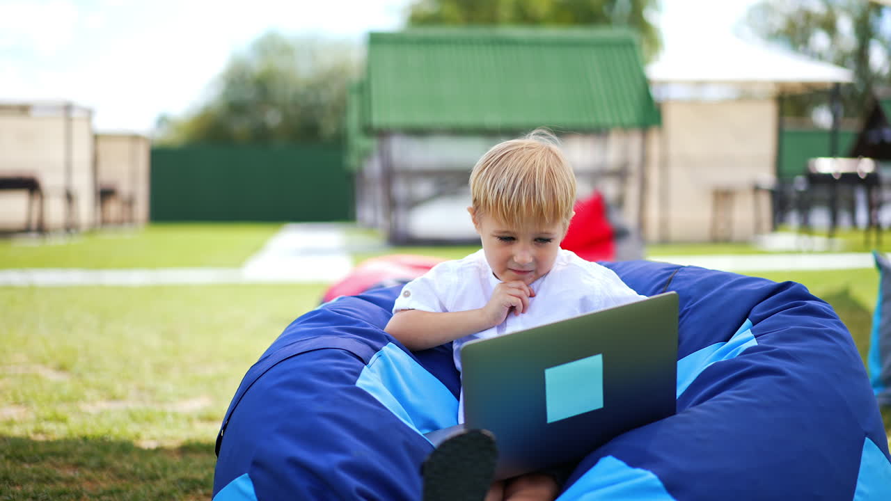 Child learning on a laptop outdoors