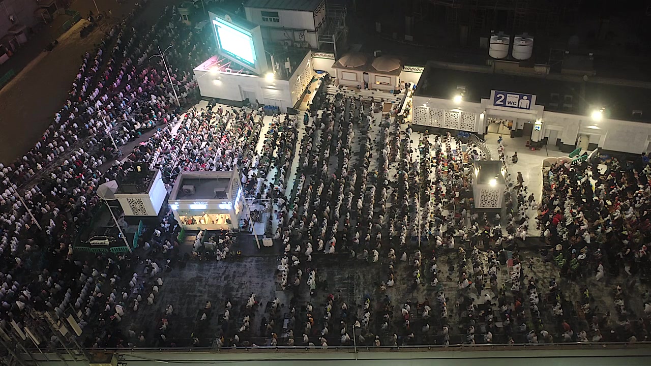 Large Crowd of People Praying Together at Night