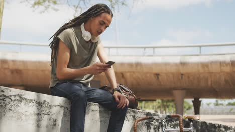 Mixed-race-man-using-his-phone-outside