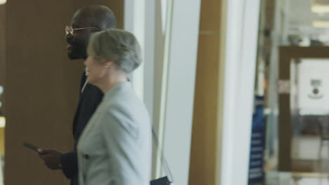 businesswoman entering hotel and greeting manager