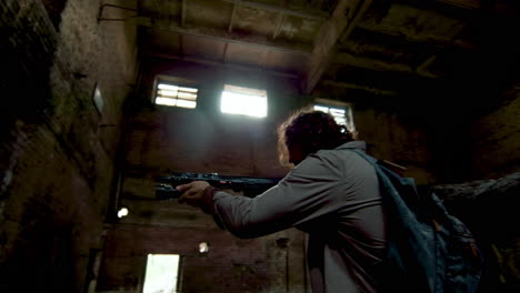 un homme avec une arme dans une maison abandonnée.