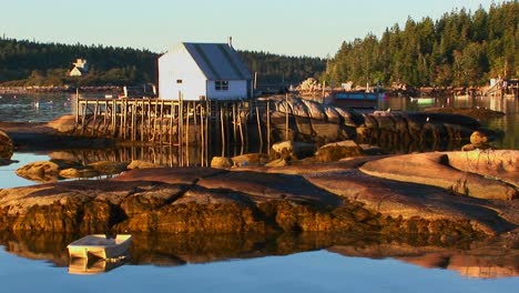 a small lobster village building in stonington maine is on a rock island and pier