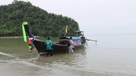 boat docking and people disembarking at beach