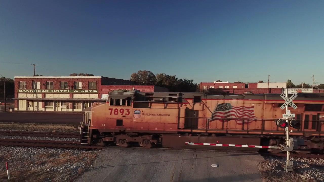 Dronevideo af et tog, der kører forbi i en lille landlig by i Texas