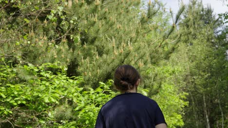 Mujer-Caminando-En-La-Naturaleza-Con-Pinos-Y-Arbustos-Disfrutando-Del-Aire-Libre-Y-Aire-Fresco.