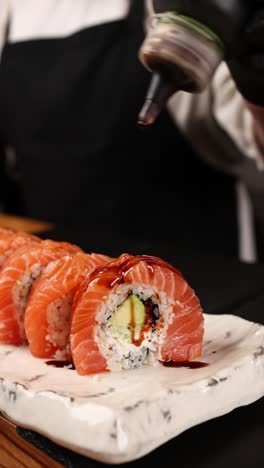 el chef preparando rollos de sushi de salmón