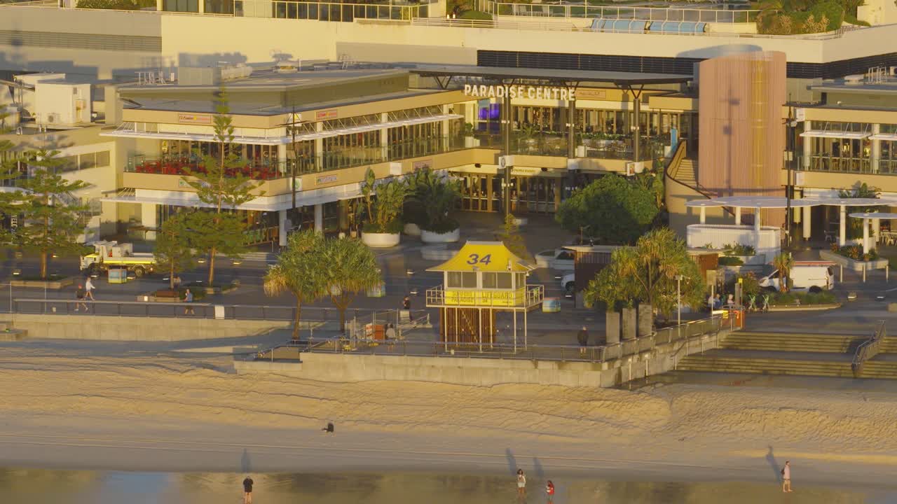 Aerial view of Surfers Paradise beach and esplanade at sunrise, capturing early morning activity and golden lighting