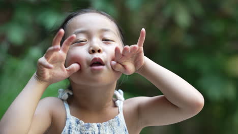 little asian kid making funny faces to the camera, close up portrait scene