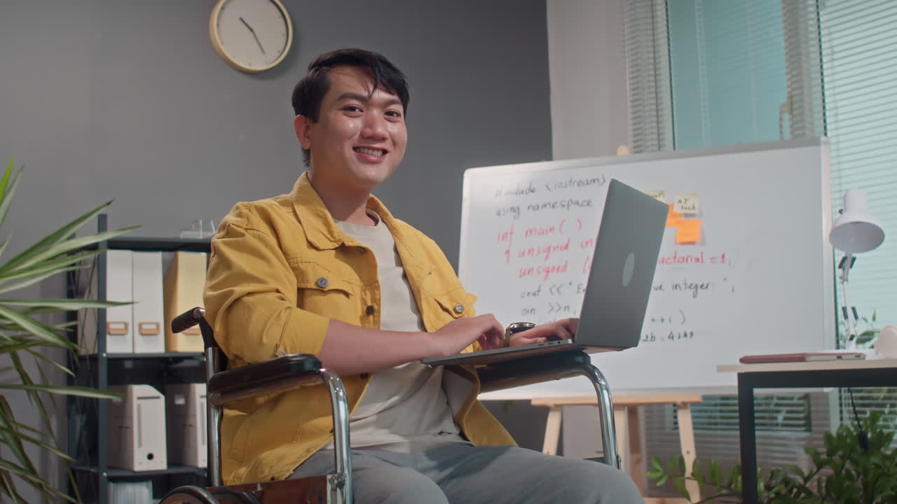 Portrait of Asian Coder in Wheelchair Working on Wireless Laptop