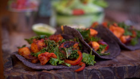 Toma-Panorámica-En-Cámara-Lenta-De-Tacos-De-Pulpo-A-La-Parrilla-Marinados-Con-Adobo-Tradicional-Mexicano-Servidos-Con-Lechuga-Sobre-Tortillas-De-Maíz-Azul.