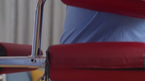 close up of a hand touching asian male crying patient's shoulder encouraging walking by walker during a physical therapy at home