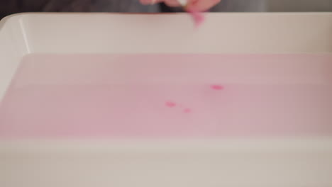 el artista se sacude la pintura cae en el agua en la lección de ebru