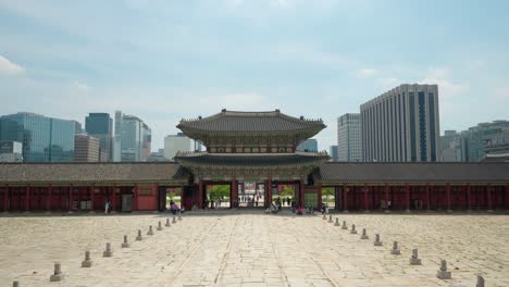 Geunjeongmun-gate-in-Gyeongbokgung-Palace-with-Seoul-modern-tower-buildings-in-background-and-blue-sky