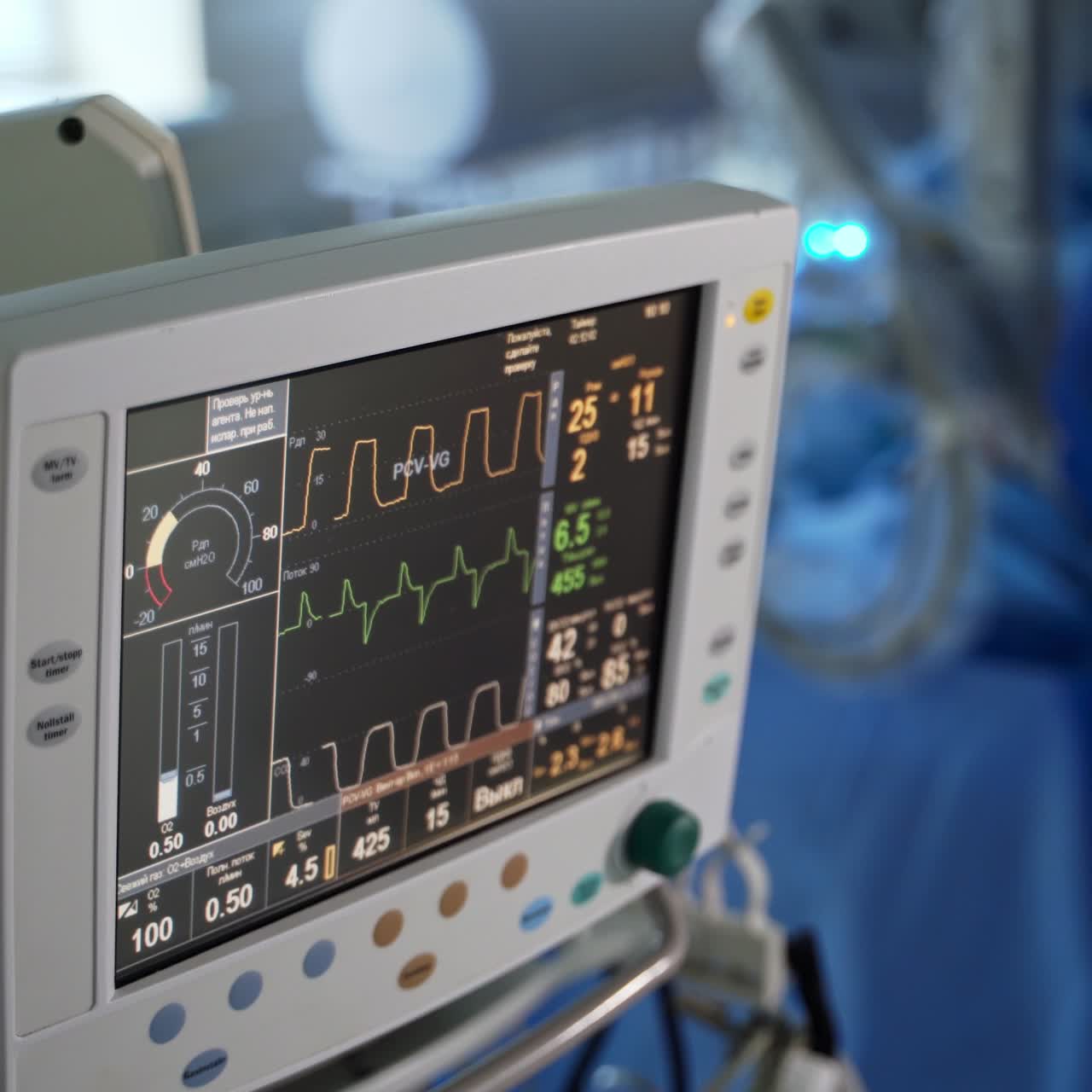 Monitor displaying patient's vital signs. Medical monitor instrument in a hospital surgery room. Surgeons at the backdrop in blur