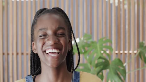 portrait of happy african american teenage girl laughing at home in slow motion