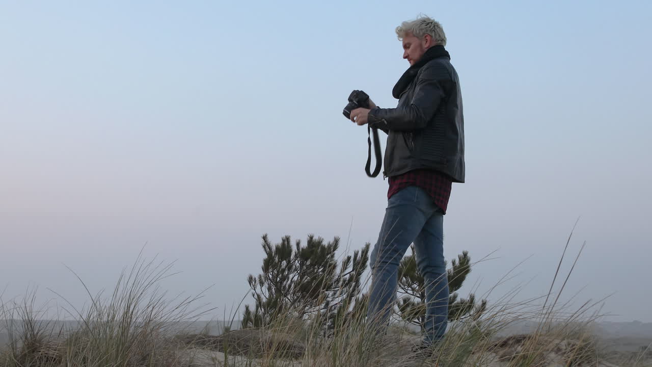 Nærbillede af en landskabsfotograf, der tager billeder i naturen ved solnedgang eller solopgang