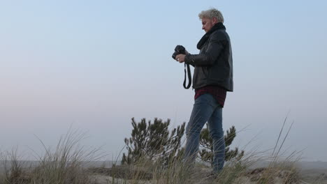 close up shot of a landscape photographer man taking photos in nature at sunset or sunrise