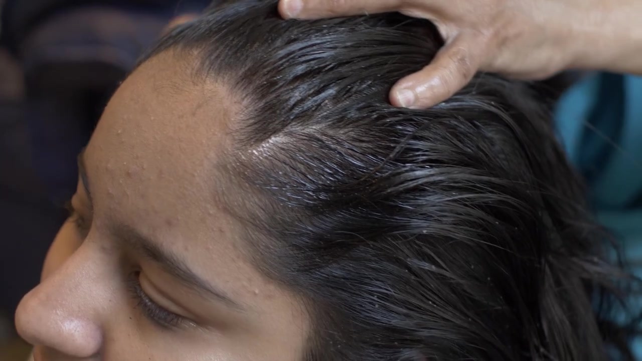 Young Asian Child Getting Oil Massaged Into Her Scalp And Hair. Close Up, Locked Off