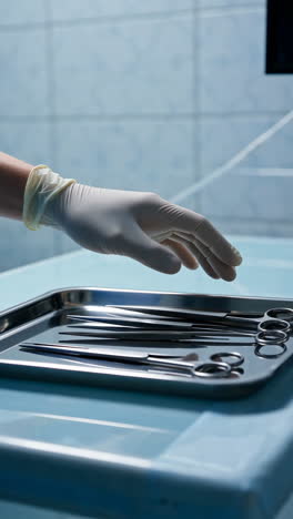 gloved hand reaching for surgical instruments in an operating room