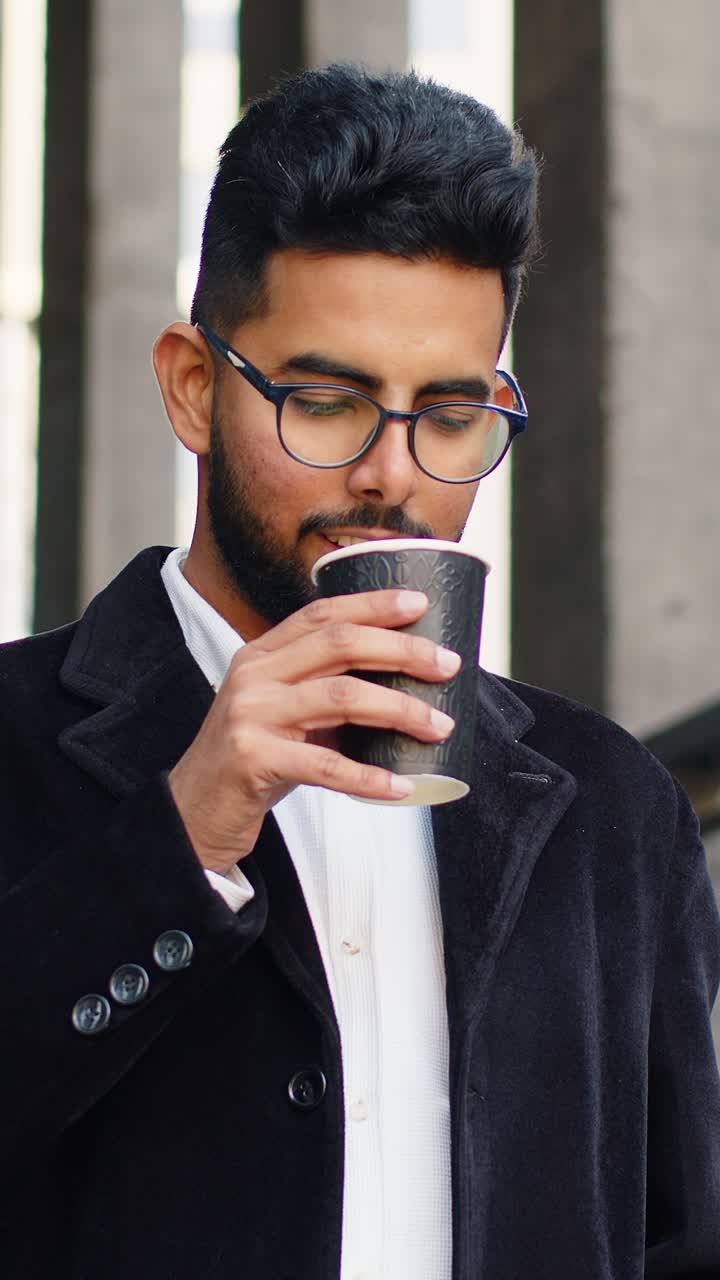 행복한 인도인 사업가 아침 커피를 즐기고 뜨거운 음료를 마시며 휴식을 취하고 있습니다.
