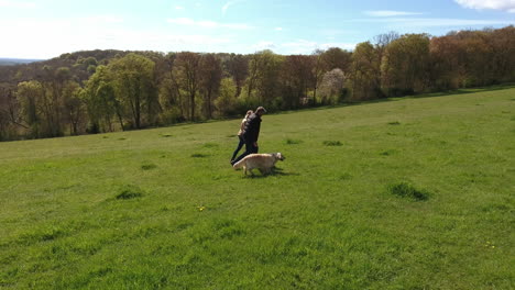 Toma-Aérea-De-La-Pareja-Madura-Y-El-Perro-A-Caminar-En-El-Campo