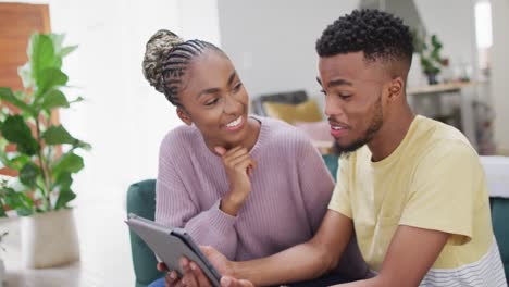 happy african american couple talking to camera during video call on tablet