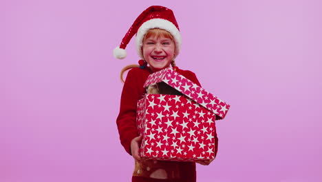 Girl-in-Christmas-red-sweater-hat-smiling,-unwrapping-gift,-opening-box-with-pet-cat,-great-surprise