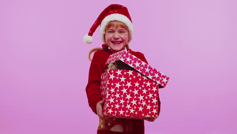 girl in christmas red sweater hat smiling, unwrapping gift, opening box with pet cat, great surprise