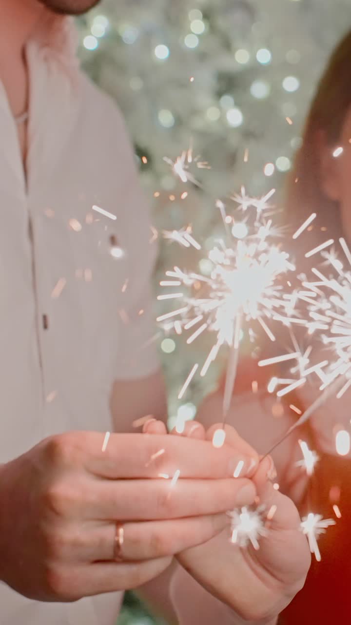 Celebrating Joyful Moments: Hands Lighting Sparklers Emitting Bright Sparks Against a Shimmering Holiday Background Filled with Joy, Togetherness, and Festive Spirit Captured in a Magical Atmosphere