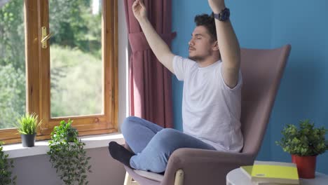 man doing yoga outside in front of the window.