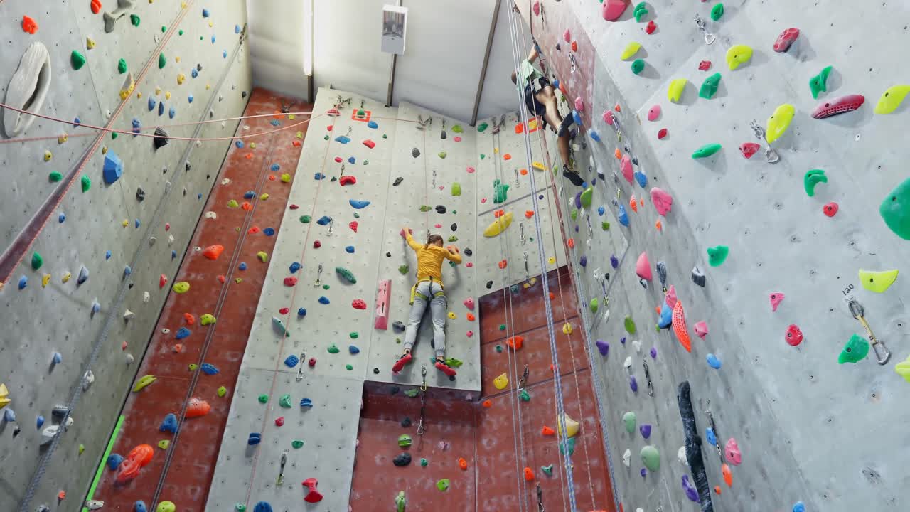 hombre y mujer practicando escalada en roca en el estudio de fitness 4k