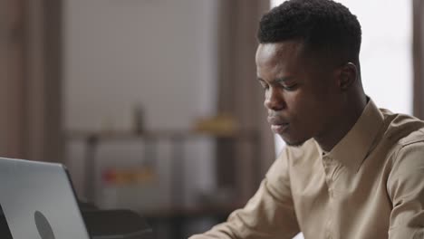 concentrated afro-american student is working, sending message and typing, office worker or freelancer, moving shot