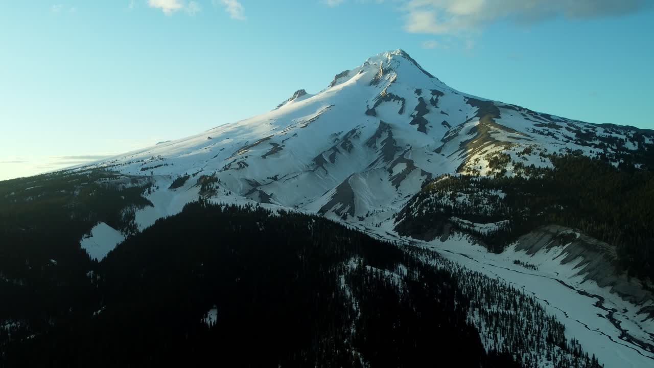 US, Oregon, Mt Hood, White River, 2025-04-22 - Drone view of Mt Hood at sunset over the White River in spring, with snow still covering the mountain and creek and trees