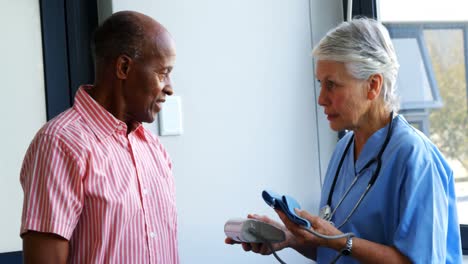 doctor explaining about blood pressure monitor to senior man 4k