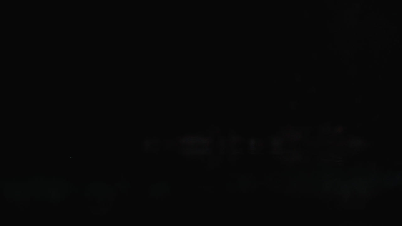 красный нарезанный перец падает на стакан с брызгами воды в медленном движении на темном фоне