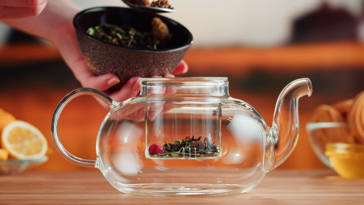 Adding loose leaf tea to a glass teapot