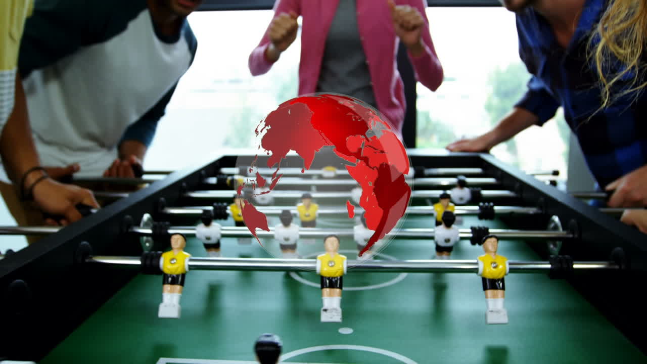 Animation of globe over diverse group of colleagues playing table football