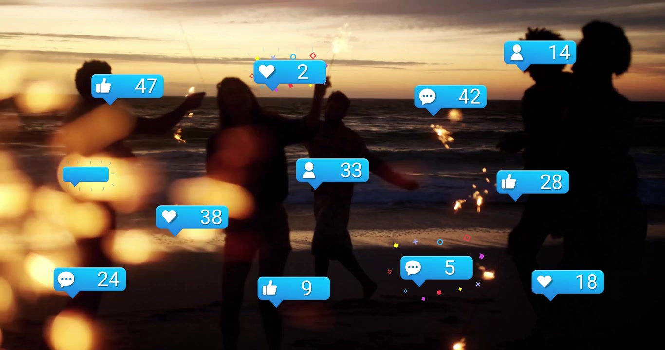 Vänner deltar i en dans med tomtebloss på en strand i solnedgången, där sociala medieikoner förstärks för att fira vänskap.