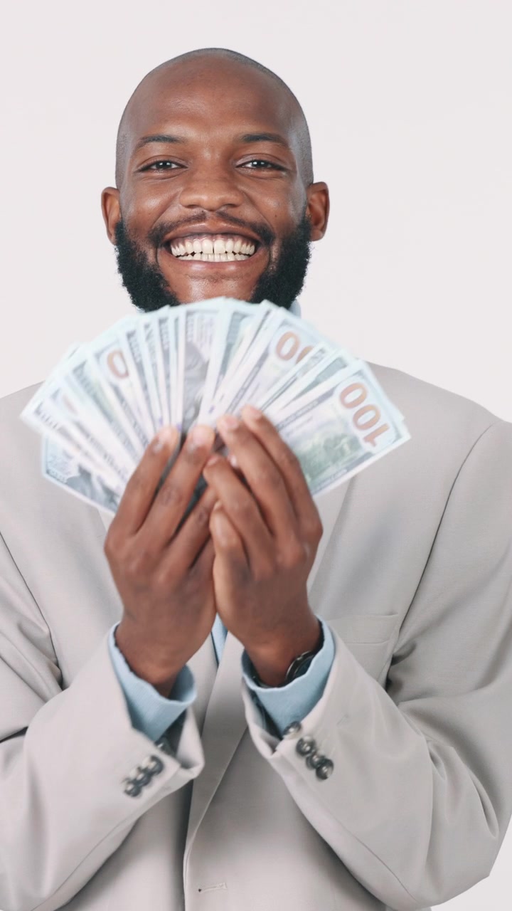 Uomo d'affari sorridente con in mano un ventaglio di banconote da dollari statunitensi