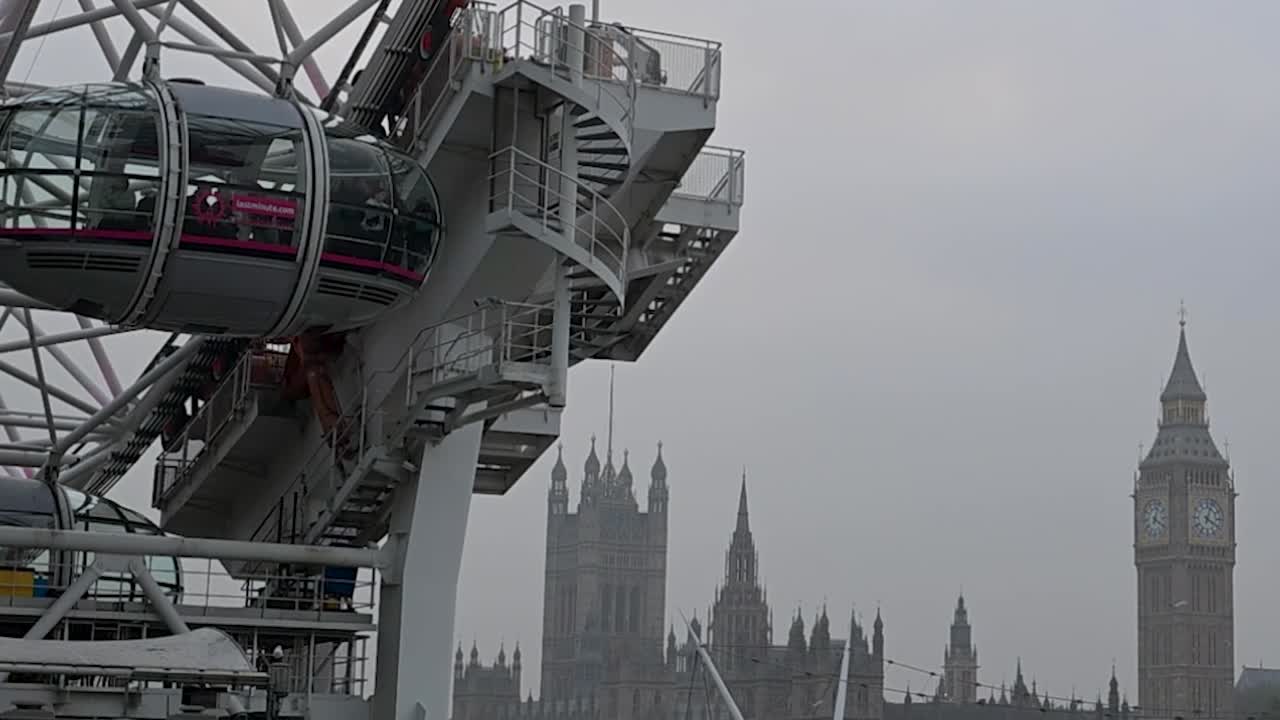 The London Eye rotating next to Big Ben, United Kingdom