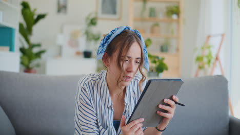 Frau-Arbeitet-Zu-Hause-Im-Wohnzimmer-An-Einem-Tablet-PC