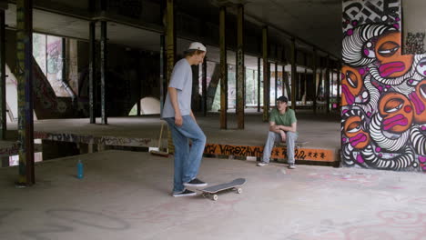 chicos caucásicos patinando en un edificio en ruinas.