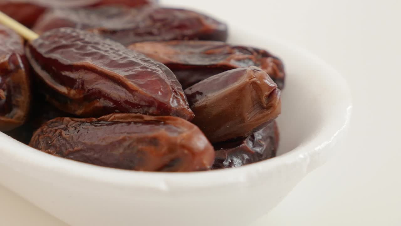 Delicious date palm exotic fruit on white background slow panning 4K 2160p UltraHD footage - Phoenix dactylifera fruit on white slow pan close-up 4K 3840X2160 UHD video