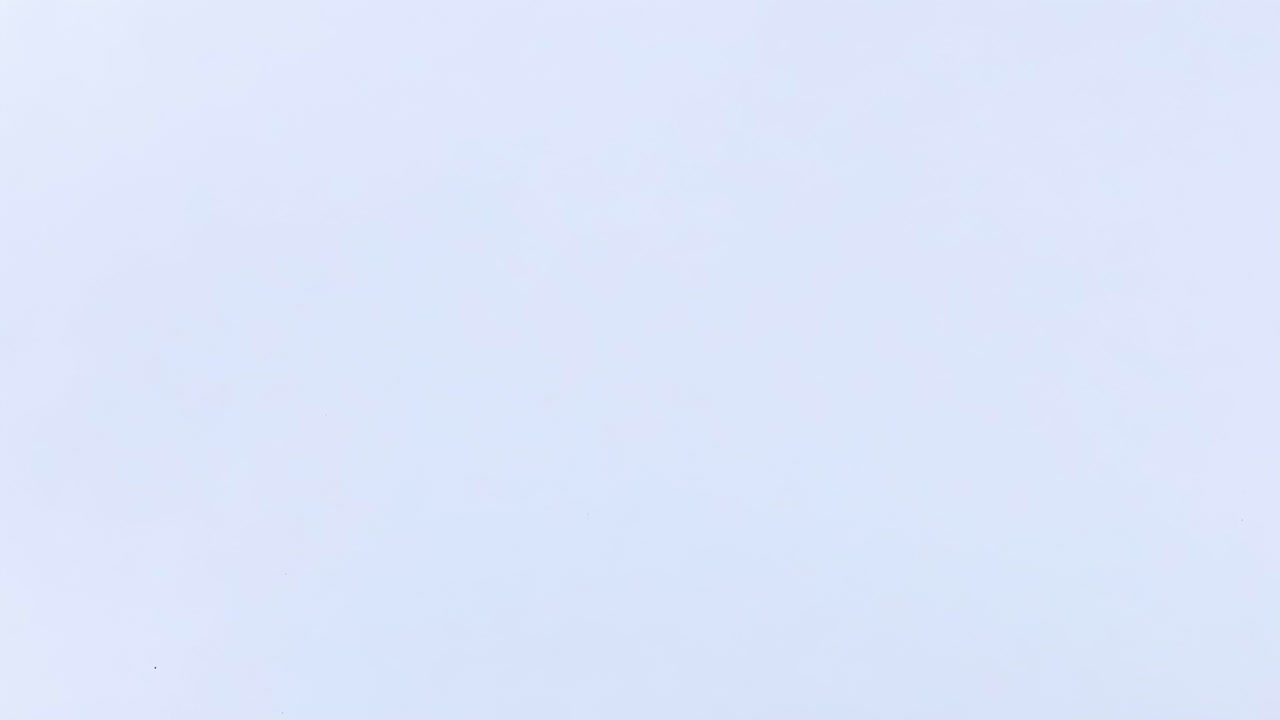 A pink tennis ball captured mid-air, showcasing its motion against a plain white background.